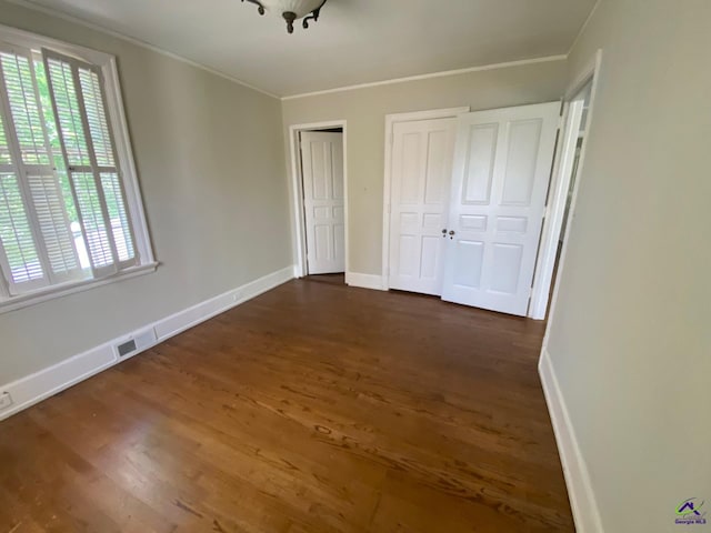 1218 Nottingham Dr, Macon, GA 31210 - unfurnished bedroom featuring visible vents, crown molding, baseboards, two closets, and dark wood-style floors