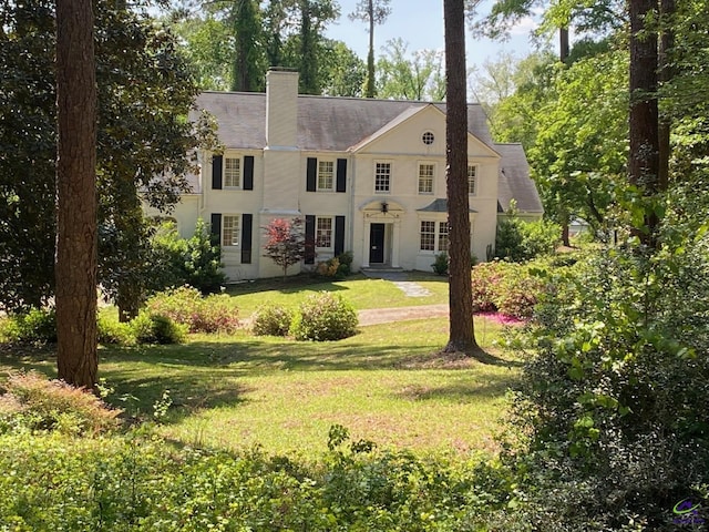 1218 Nottingham Dr, Macon, GA 31210 - colonial inspired home featuring a chimney, stucco siding, and a front yard