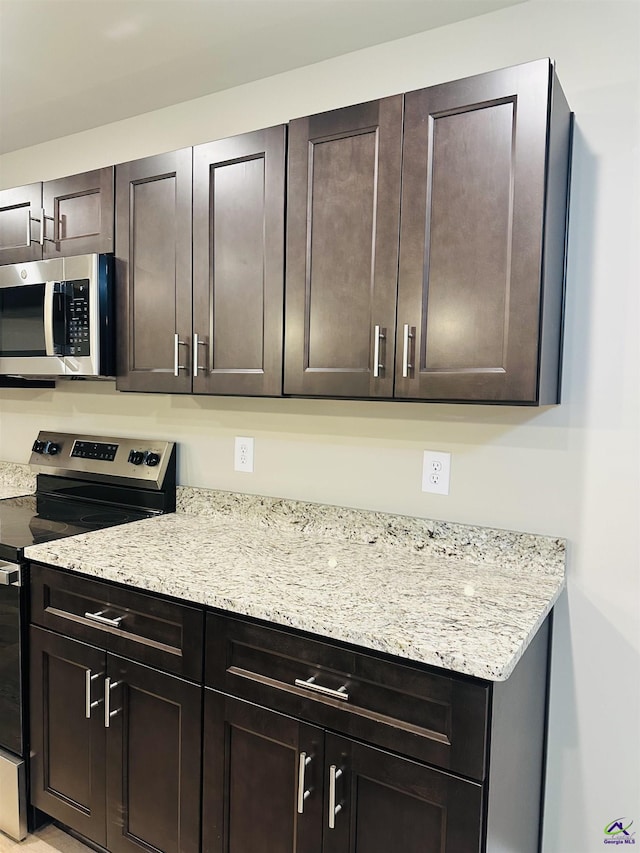 325 Peach Cir, Fort Valley, GA 31030 - kitchen with appliances with stainless steel finishes, dark brown cabinetry, and light stone counters