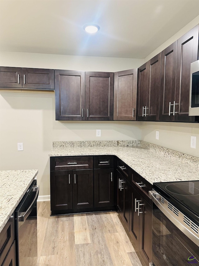 325 Peach Cir, Fort Valley, GA 31030 - kitchen with stainless steel appliances, light wood-style flooring, light stone counters, and dark brown cabinetry