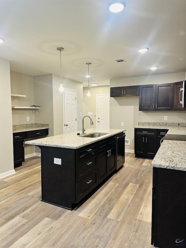 325 Peach Cir, Fort Valley, GA 31030 - kitchen featuring dishwashing machine, light wood-style flooring, dark cabinetry, and a kitchen island with sink