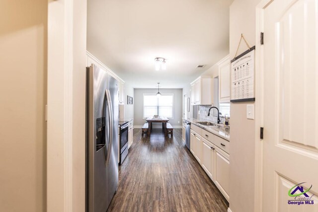 122 Milford Cir, Perry, GA 31069 - kitchen featuring appliances with stainless steel finishes, dark wood finished floors, a sink, baseboards, and white cabinetry