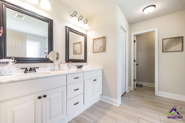122 Milford Cir, Perry, GA 31069 - full bath featuring double vanity, baseboards, wood finish floors, and a sink
