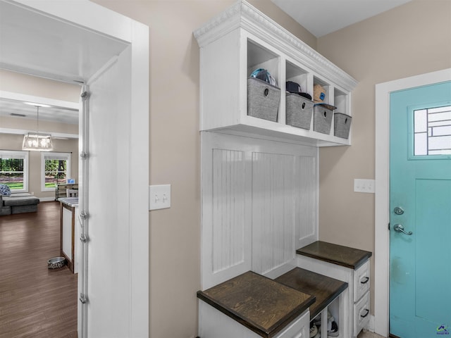 mudroom with dark wood-type flooring, a chandelier, and visible vents