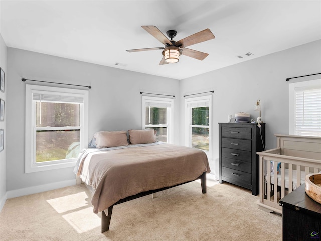 bedroom with light colored carpet, multiple windows, and visible vents