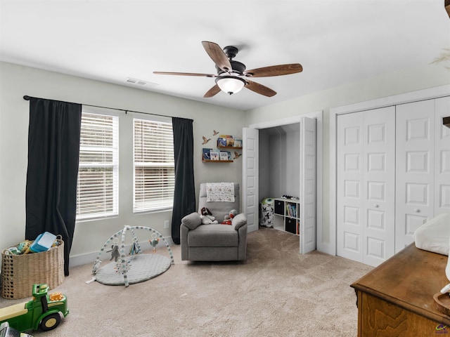 sitting room with baseboards, carpet, a ceiling fan, and visible vents