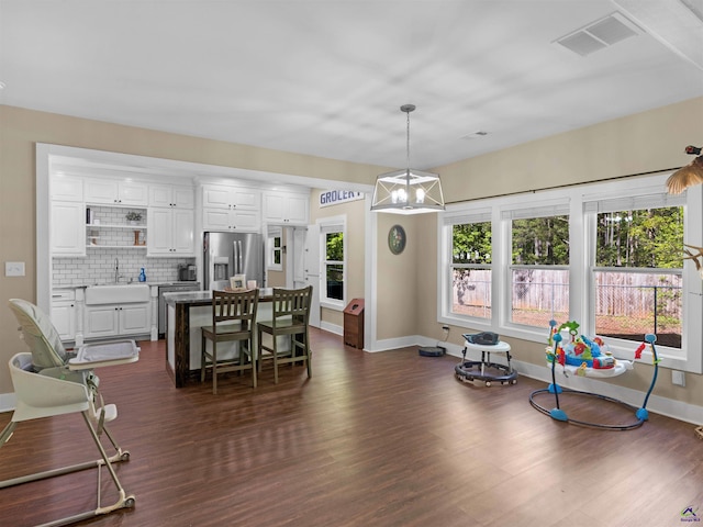 interior space featuring baseboards, dark wood finished floors, a chandelier, and visible vents