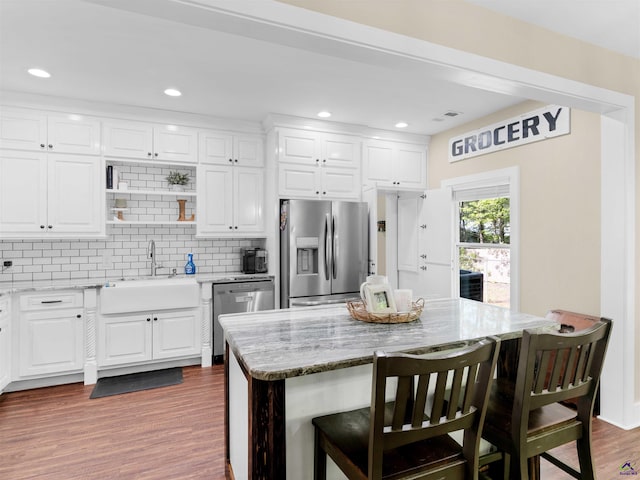 kitchen featuring a sink, wood finished floors, a breakfast bar, and stainless steel appliances