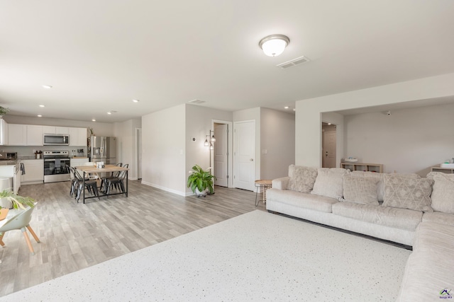 living area with recessed lighting, baseboards, light wood-type flooring, and visible vents