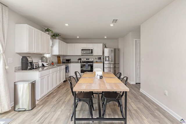 dining room with recessed lighting, baseboards, light wood finished floors, and visible vents