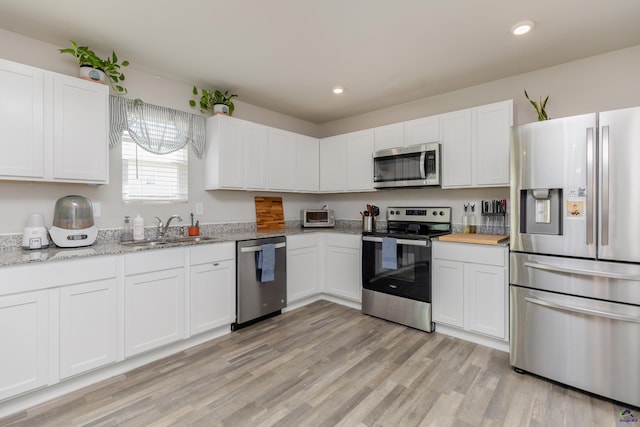 kitchen with white cabinetry, appliances with stainless steel finishes, a sink, and recessed lighting