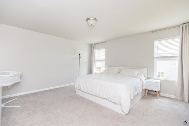 bedroom with baseboards and light carpet