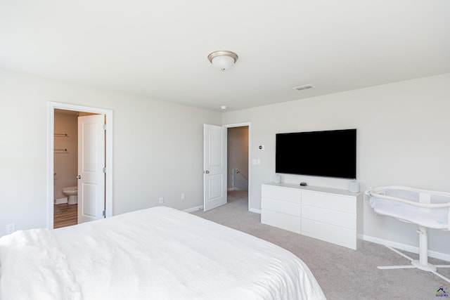 bedroom featuring baseboards, ensuite bath, carpet floors, and visible vents