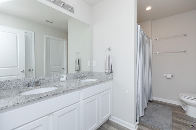 bathroom featuring visible vents, a sink, and wood finished floors