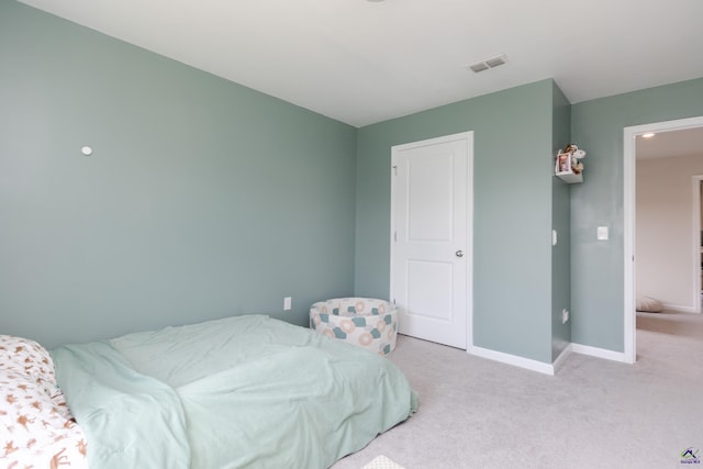 bedroom with baseboards, light carpet, and visible vents