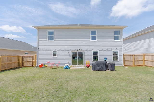 back of house with a fenced backyard and a yard