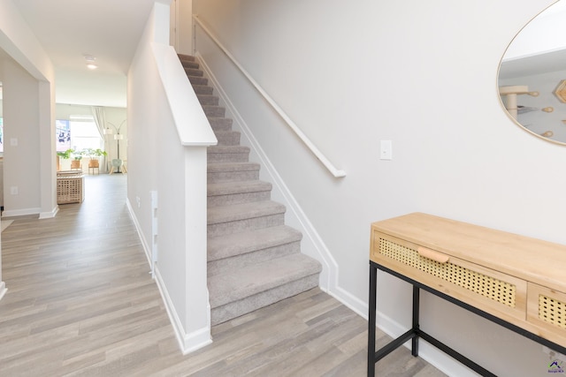 stairway featuring recessed lighting, baseboards, and wood finished floors