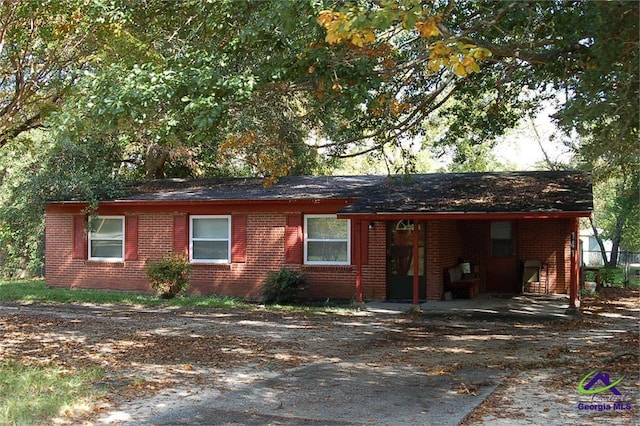 single story home featuring brick siding and driveway