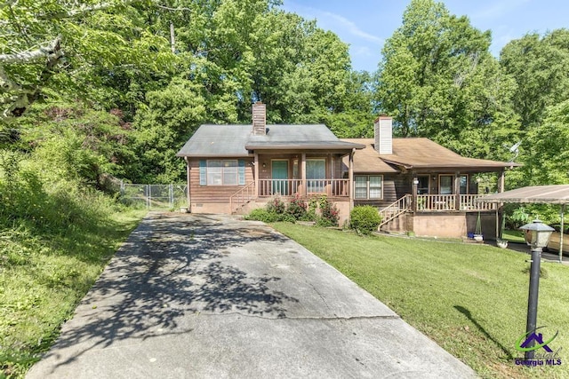 410 Steeplechase Rd, Macon, GA 31216 - view of front of home featuring a porch, a chimney, a front yard, fence, and concrete driveway