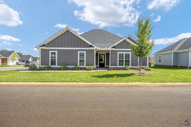 craftsman house featuring a shingled roof, board and batten siding, and a front yard
