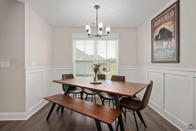 dining area featuring a decorative wall, a chandelier, and dark wood-type flooring