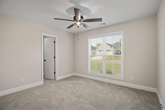 spare room with carpet floors, a ceiling fan, baseboards, and visible vents