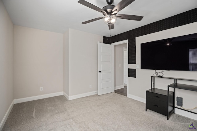 interior space featuring baseboards, a ceiling fan, and carpet