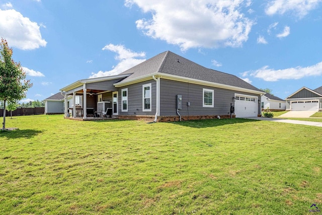 back of property featuring ceiling fan, a lawn, fence, concrete driveway, and an attached garage