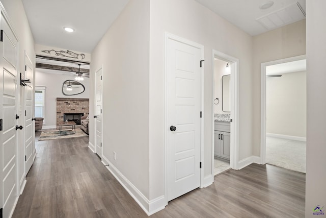 corridor featuring baseboards, visible vents, and dark wood finished floors