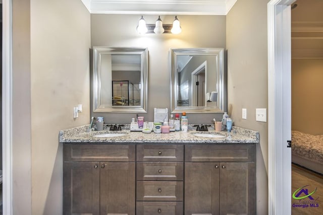 bathroom featuring crown molding, a sink, ensuite bathroom, and double vanity