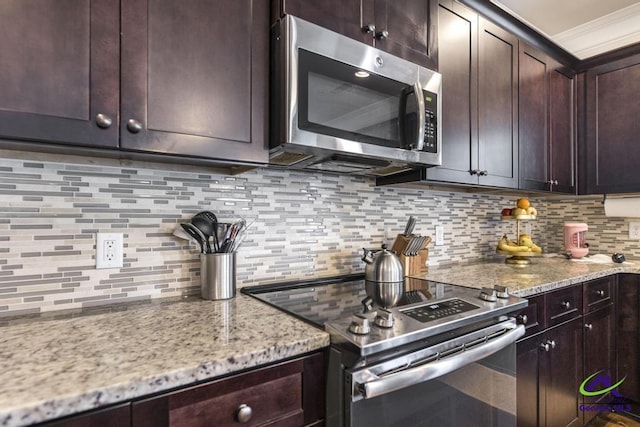 kitchen featuring dark brown cabinets, light stone countertops, appliances with stainless steel finishes, and tasteful backsplash