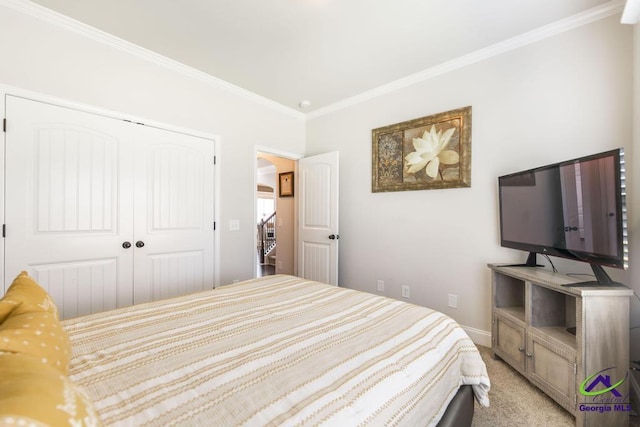 bedroom with baseboards, ornamental molding, light carpet, and a closet