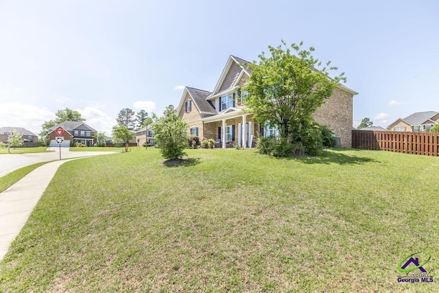 exterior space with a residential view, fence, and a front yard