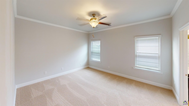 unfurnished room with crown molding, a ceiling fan, baseboards, and light colored carpet