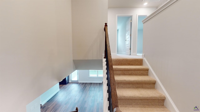 stairway with baseboards and wood finished floors