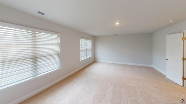 spare room with visible vents, recessed lighting, baseboards, and light colored carpet