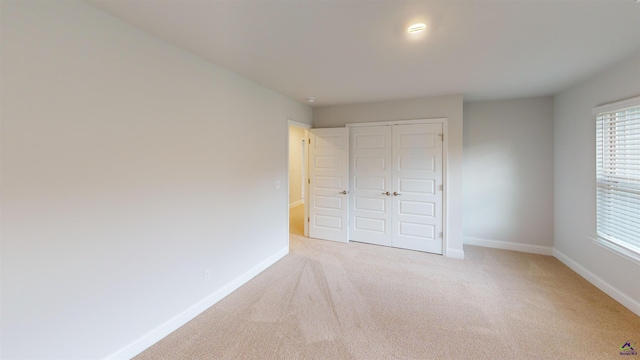 unfurnished bedroom with a closet, baseboards, and carpet flooring