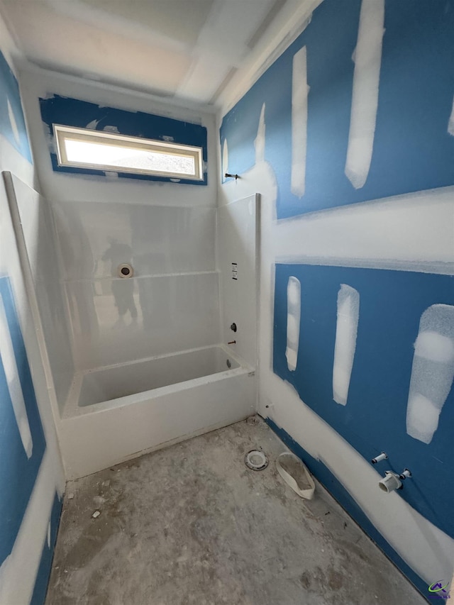bathroom with concrete flooring and bathtub / shower combination