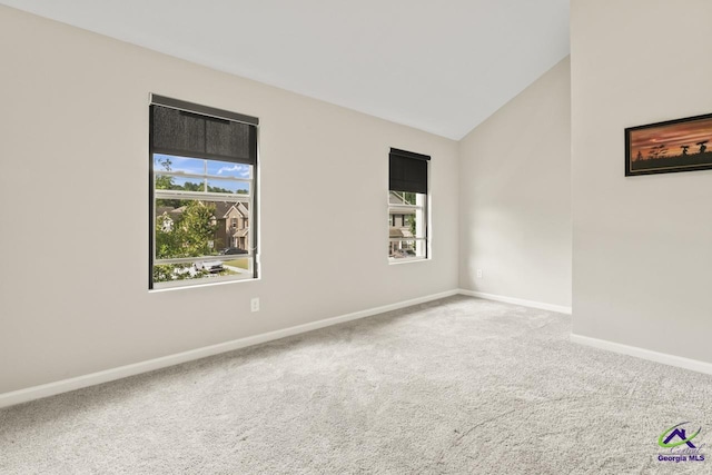5768 Grande River Rd, Atlanta, GA 30349 - carpeted spare room featuring plenty of natural light, baseboards, and vaulted ceiling