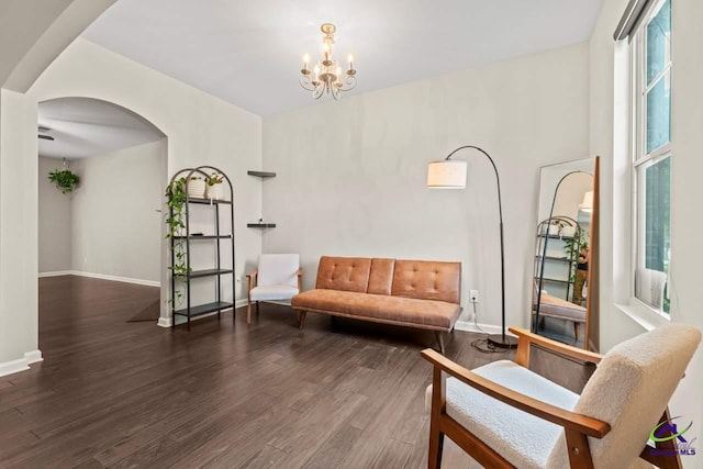 5768 Grande River Rd, Atlanta, GA 30349 - sitting room featuring arched walkways, baseboards, wood finished floors, and a notable chandelier