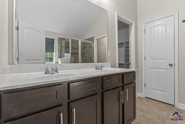 5768 Grande River Rd, Atlanta, GA 30349 - full bath featuring double vanity, a sink, lofted ceiling, and a stall shower