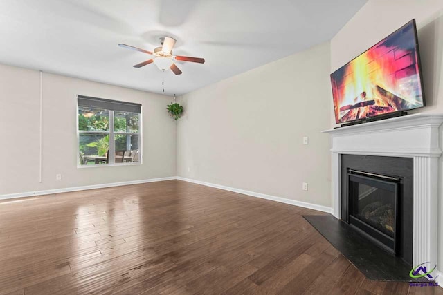 5768 Grande River Rd, Atlanta, GA 30349 - unfurnished living room featuring a ceiling fan, baseboards, a glass covered fireplace, and wood finished floors