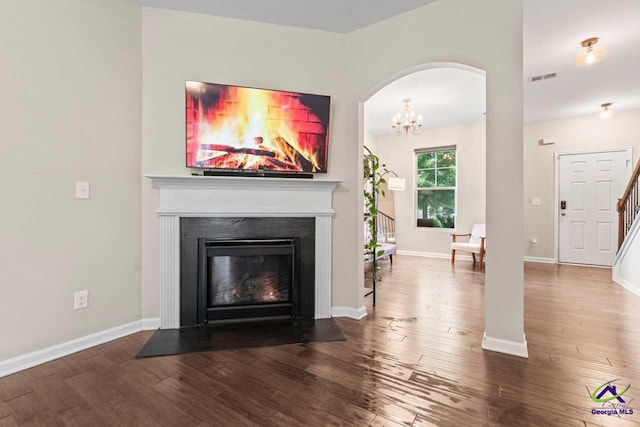 5768 Grande River Rd, Atlanta, GA 30349 - living area with visible vents, a fireplace with flush hearth, arched walkways, and wood finished floors
