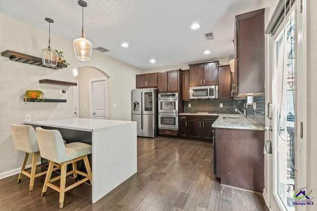 5768 Grande River Rd, Atlanta, GA 30349 - kitchen featuring dark brown cabinets, appliances with stainless steel finishes, a sink, arched walkways, and visible vents