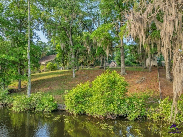 view of home's community featuring fence and a water view
