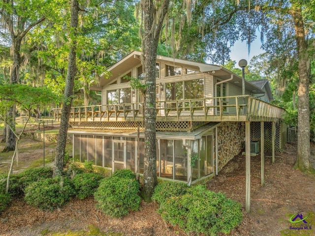 back of property with central air condition unit, a wooden deck, and a sunroom