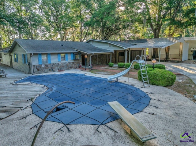 view of pool featuring a patio, a water slide, and a covered pool