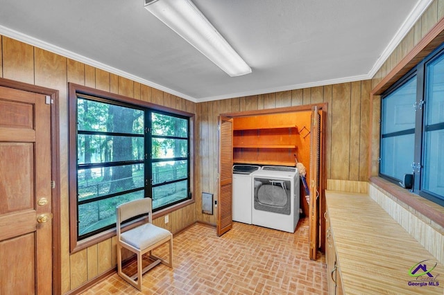 laundry room with separate washer and dryer, laundry area, brick patterned floor, and wood walls