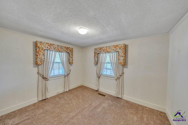 unfurnished room featuring crown molding, light colored carpet, a textured ceiling, baseboards, and visible vents