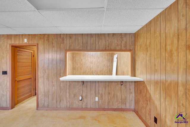 details featuring a drop ceiling and wood walls